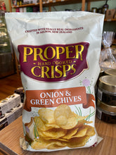 Bag of Proper Crisps with onion and green chives flavor on a wooden surface.