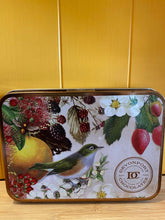 Devonport Chocolates Vintage Tin with decorative artwork showing native birds, trees, and insects, and containing nine chocolates.