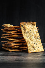 Stack of Bark lavosh crackers on a dark surface with a black background